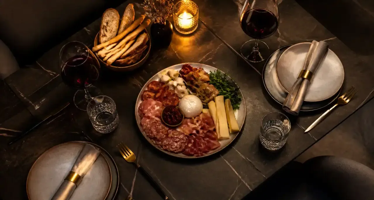Table de restaurant dress&eacute;e avec plats et verres de vin pour un accord mets et vins